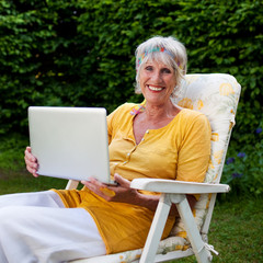 Poster - seniorin mit laptop im garten