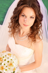 Beautiful woman with in  wedding dress over blue studio backgrou