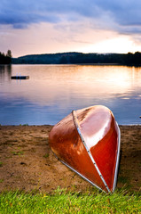 Canvas Print - Lake sunset with canoe on beach