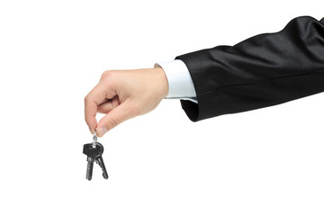 Man in a black suit holding keys isolated on white