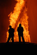 two firemen battling against raging fire