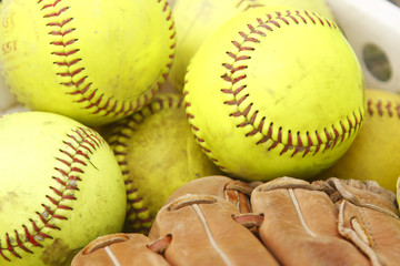 Pile of softballs and baseball glove