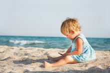 Cute Toddler Girl Playing On Beach
