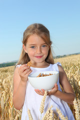 Wall Mural - Closeup of little girl holding bowl of cereals