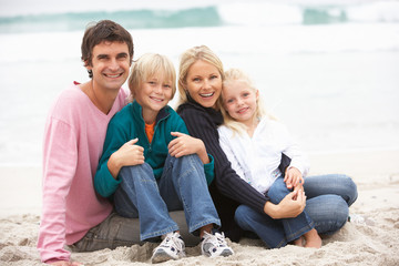 Wall Mural - Young Family Sitting On Winter Beach