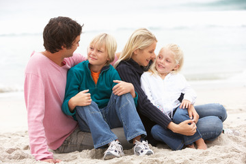 Wall Mural - Young Family Sitting On Winter Beach