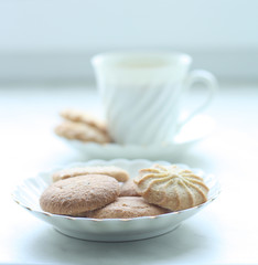 A cup of cofee or tea with biscuits