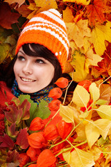Wall Mural - girl in autumn orange hat on leaves.