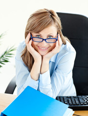 Canvas Print - Charming businesswoman smiling at the camera sitting at her desk