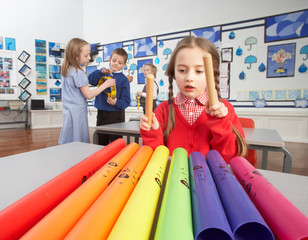 group of primary schoolchildren having music lesson in classroom
