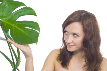 Young woman touching a green plant - isolated over white