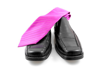 Pair of black male business shoes and pink tie