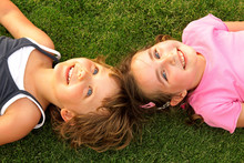 Two Smiling Girl Lying On The Grass