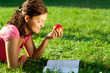 Attractive girl with book and apple in park