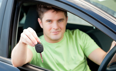 Happy caucasian man holding a car key