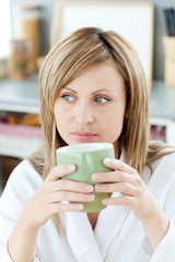 Sticker - Charming caucasian blond woman enjoying her coffee in the kitche