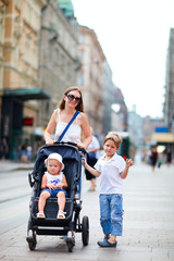 Canvas Print - Mother and two kids walking in city center