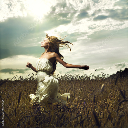 Fototapeta na wymiar Girl running across field