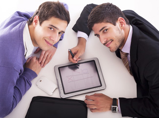 two businessmen playing on tablet computer