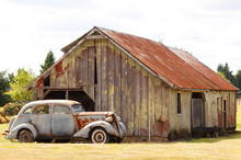 An Old Car Next To A Barn.