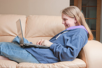 teenager using laptop on sofa