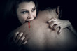 Evil vampire girl sucking blood from lover neck