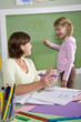 © Kablonk Micro - School girl and teacher by blackboard in classroom