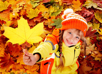 Wall Mural - child in autumn orange leaves.