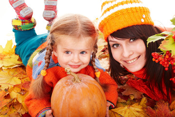 Wall Mural - happy family with pumpkin on autumn leaves.