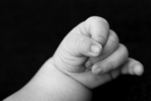 Tiny Baby's Hand Over Black