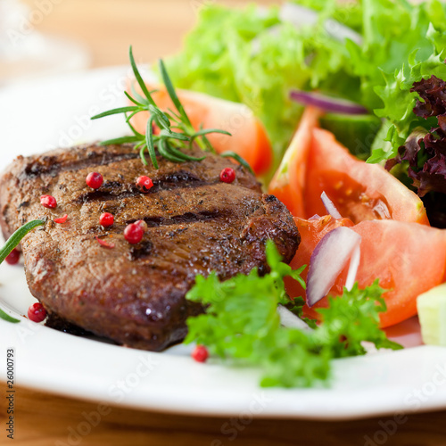 Fotografia Grilled steak with fresh vegetables and herbs