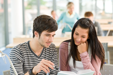 Two students read book in classroom