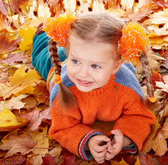 Wall Mural - girl child in autumn orange leaves.