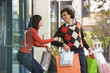 © Don Mason/Blend Images - Woman trying to pull boyfriend back into store