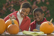 © JGI/Tom Grill/Blend Images - African mother and son carving pumpkins