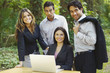 © Karin Dreyer/Blend Images - Hispanic business people using laptop in woods