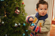 © Keith Brofsky/Blend Images - Mixed race boy decorating Christmas tree