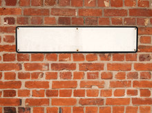 Old Blank White British Street Sign On A Red Brick Wall.