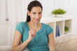 © JR Carvey/Streetfly Studio/Blend Images - Hispanic woman holding pen on sofa