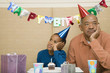 © Paul Burns/Blend Images - African boy with grandfather and cupcake at birthday party