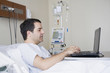 © REB Images/Blend Images - Hispanic man using laptop in hospital