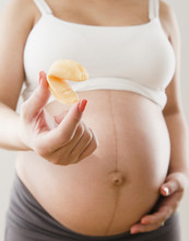 Pregnant Hispanic Woman Holding Fortune Cookie