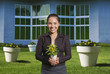 © PBNJ Productions/Blend Images - Mixed race woman holding flowers in pot