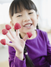 Chinese Girl With Raspberries On Fingers