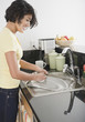 © JGI/Jamie Grill/Blend Images - Hispanic woman washing pan in kitchen