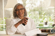 © Mark Edward Atkinson/Blend Images - Black woman holding paper and cell phone