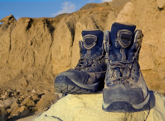 Tourists boots on stone in mountains