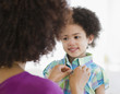 © JGI/Jamie Grill/Blend Images - Mother buttoning shirt of daughter