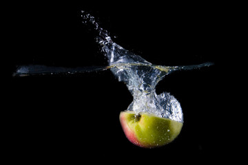 Apple splashing on black background