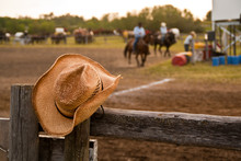 Cowboy Hat Hung On The Fence At A Rodeo With Horses And Riders